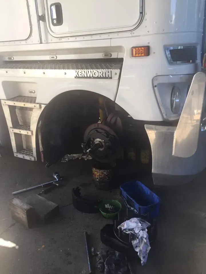 A White Kenworth Semi-truck With Its Front Wheel Removed — Mid North Coast Heavy Vehicle Repairs In Taree, NSW
