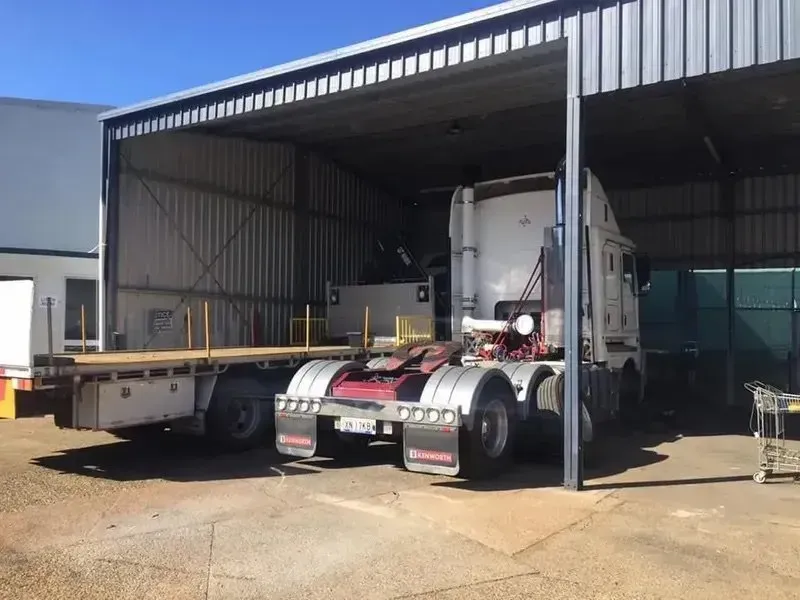 A Semi-truck and a Flatbed Trailer Parked Under Outdoor Shelter — Mid North Coast Heavy Vehicle Repairs In Lake Cathie, NSW