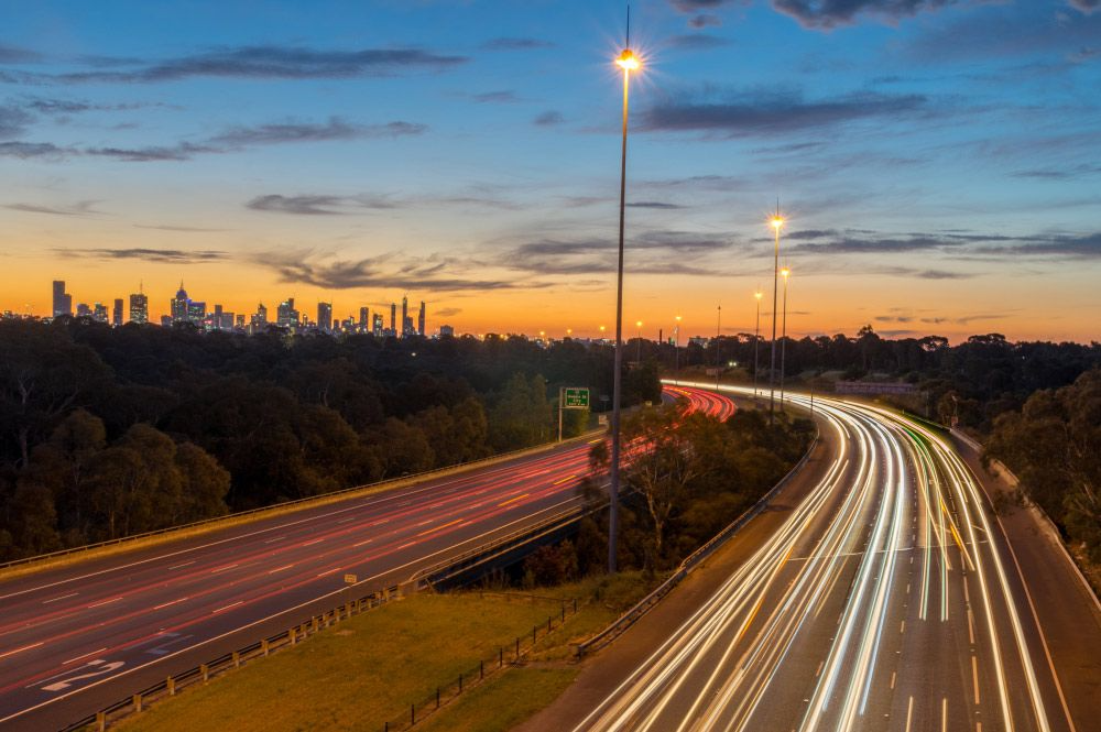 A Cityscape at Twilight Features a Long Highway — Mid North Coast Heavy Vehicle Repairs In Kew, NSW