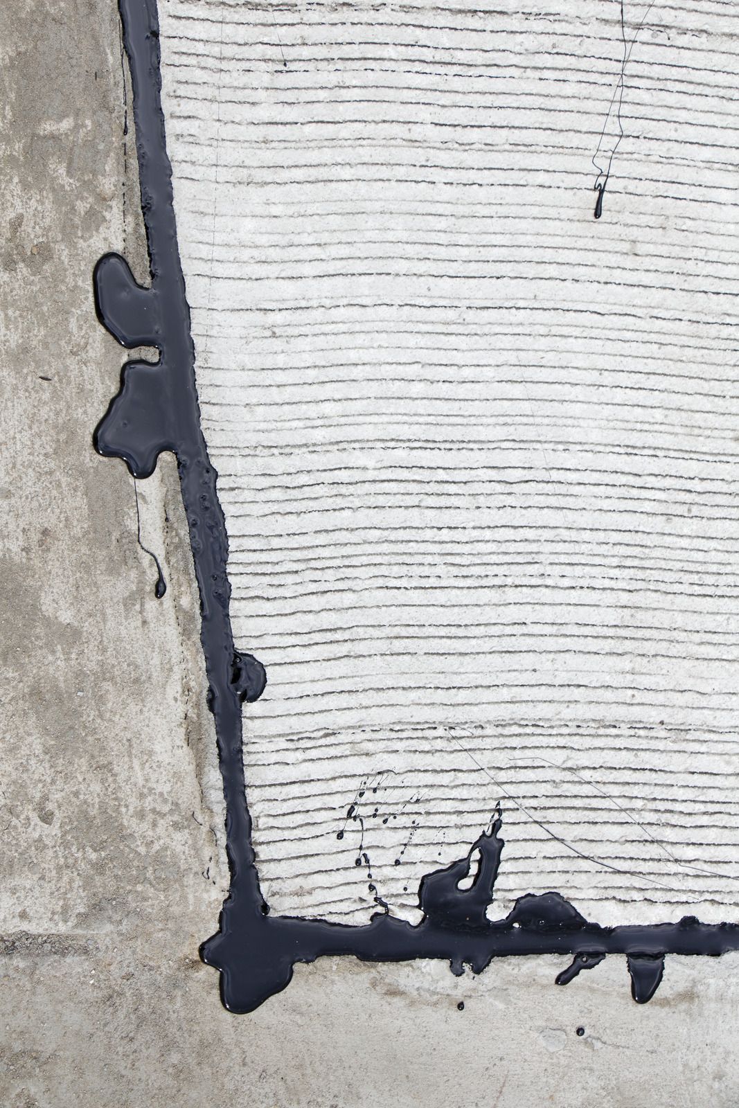 A close up of a concrete surface with black paint on it