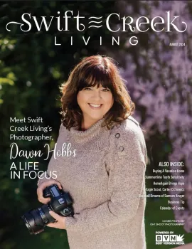 Magazine cover featuring a smiling woman holding a camera in a purple floral sweater outdoors