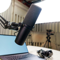 Microphone on boom arm over laptop in a podcast or recording studio