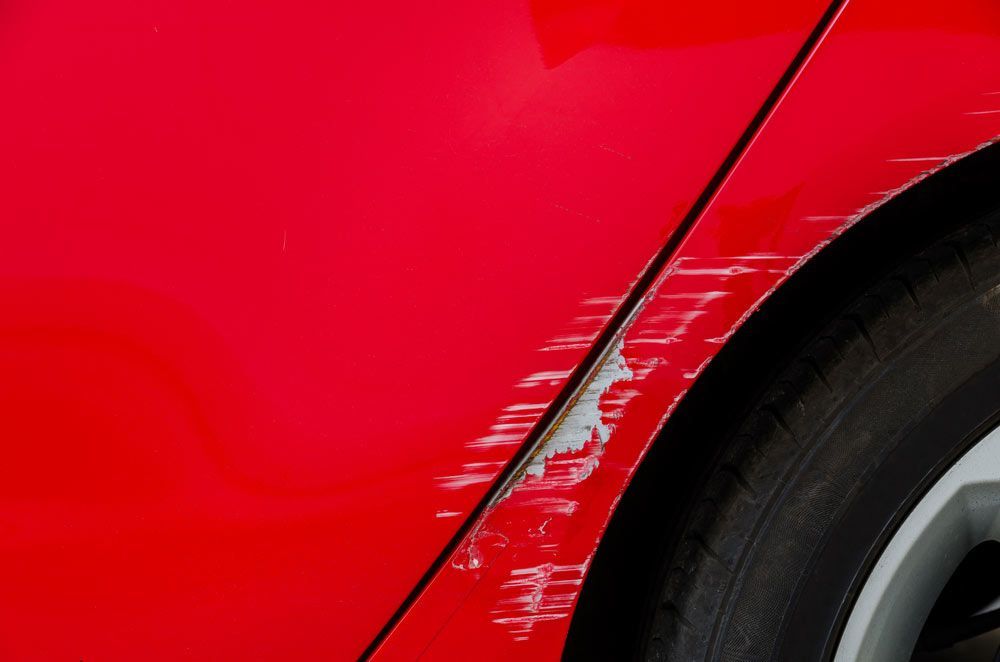 A Close Up Of A Red Car With A Scratch On The Side — Atherton Smash Repair Specialist in Atherton, QLD