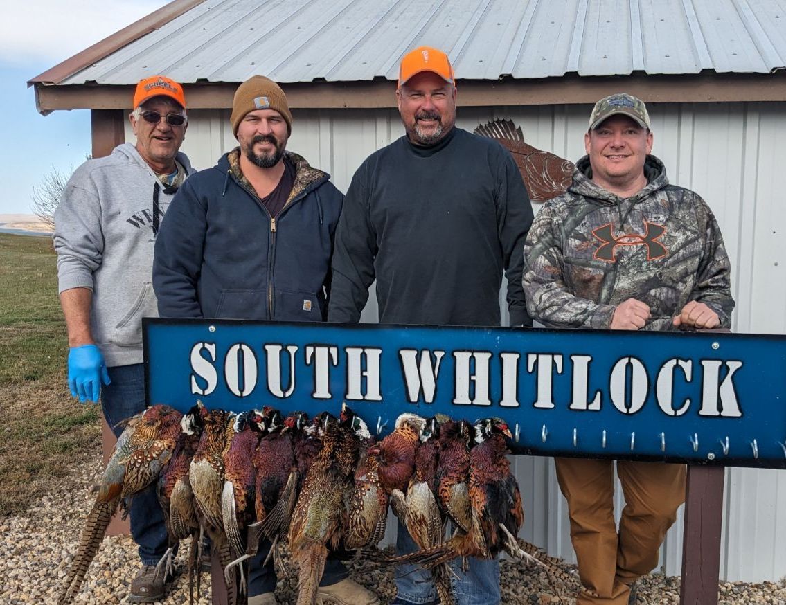 A group of men standing next to a sign that says south whitlock