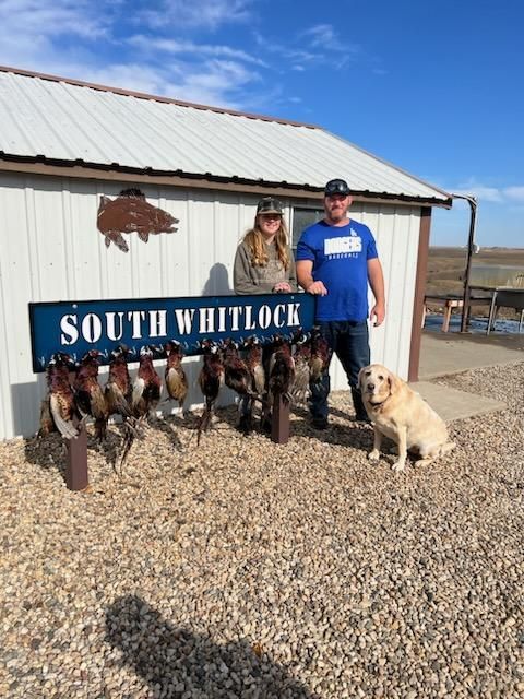 A man and woman standing next to a sign that says south whitlock