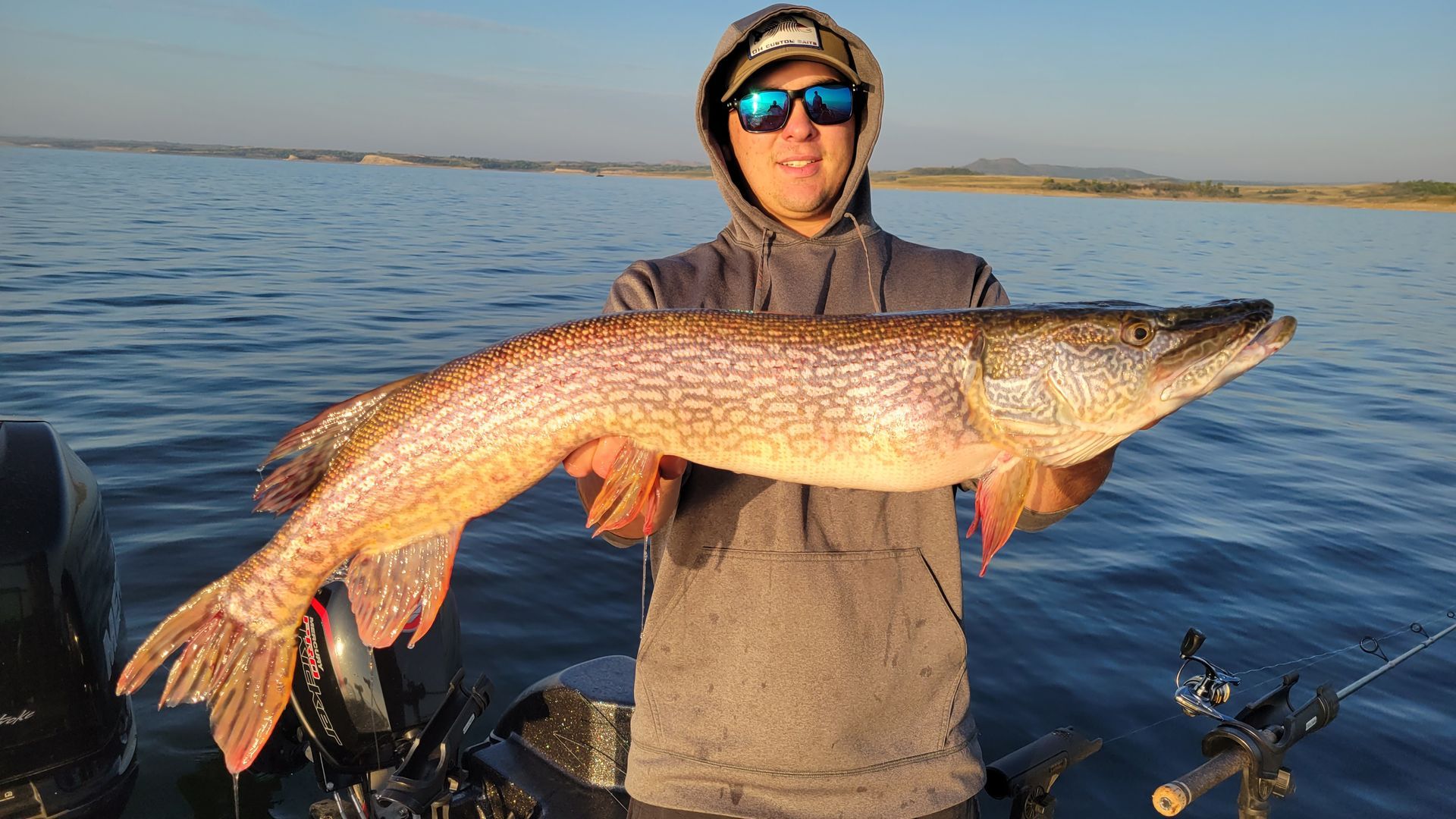 A man is holding a large fish in the water.