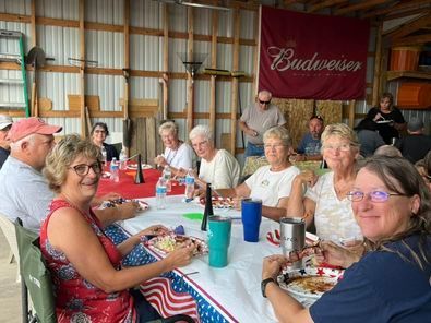 A group of people are sitting at a long table in front of a budweiser banner.