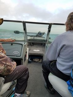 A man and a woman are sitting on a boat in the water.