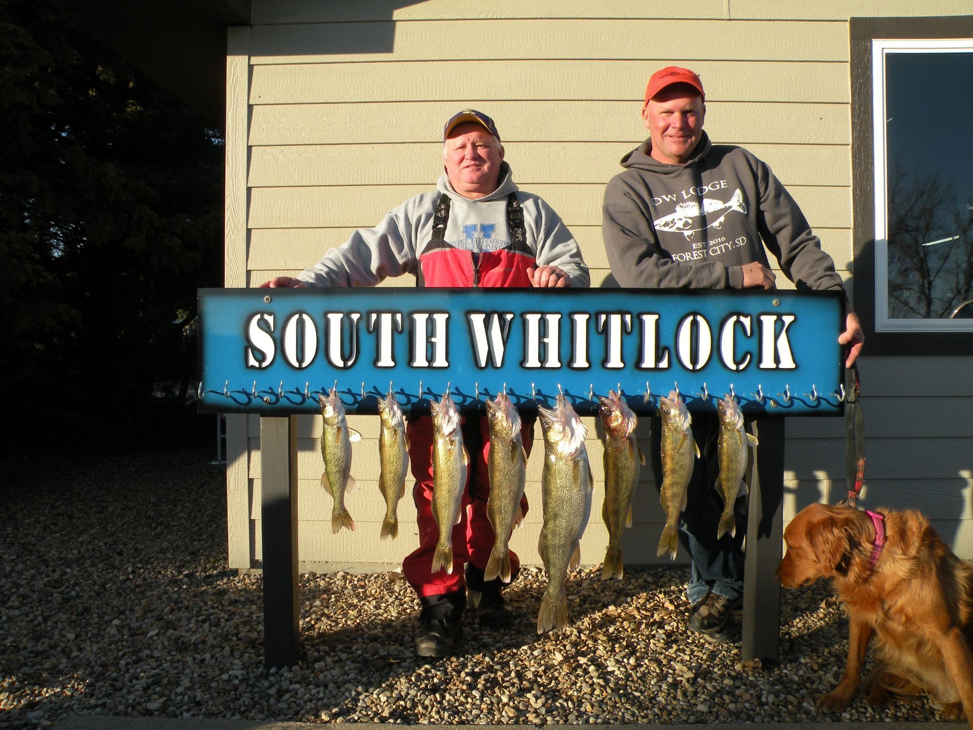 Two men holding a sign that says south whitlock