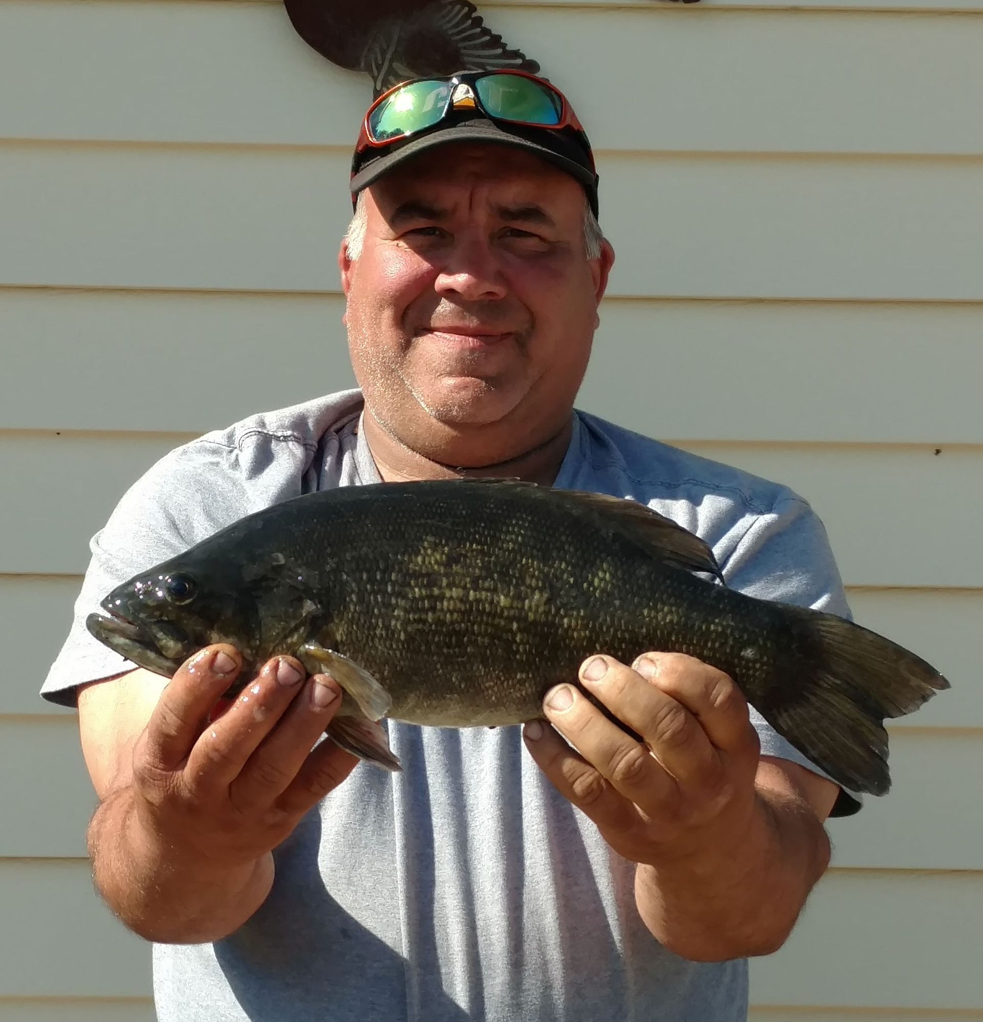 A man is holding a large fish in his hands