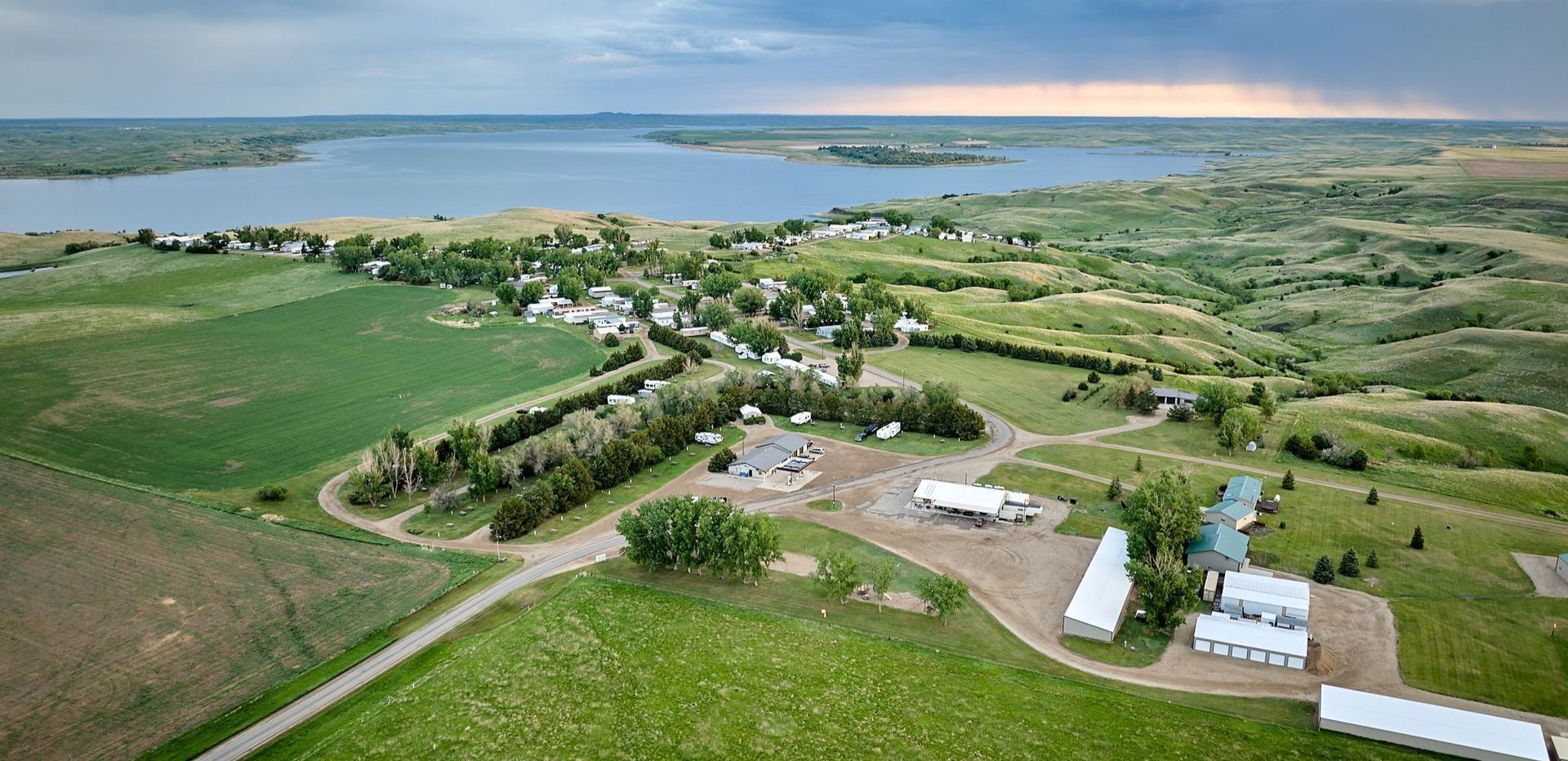 An aerial view of a farm with a lake in the background.