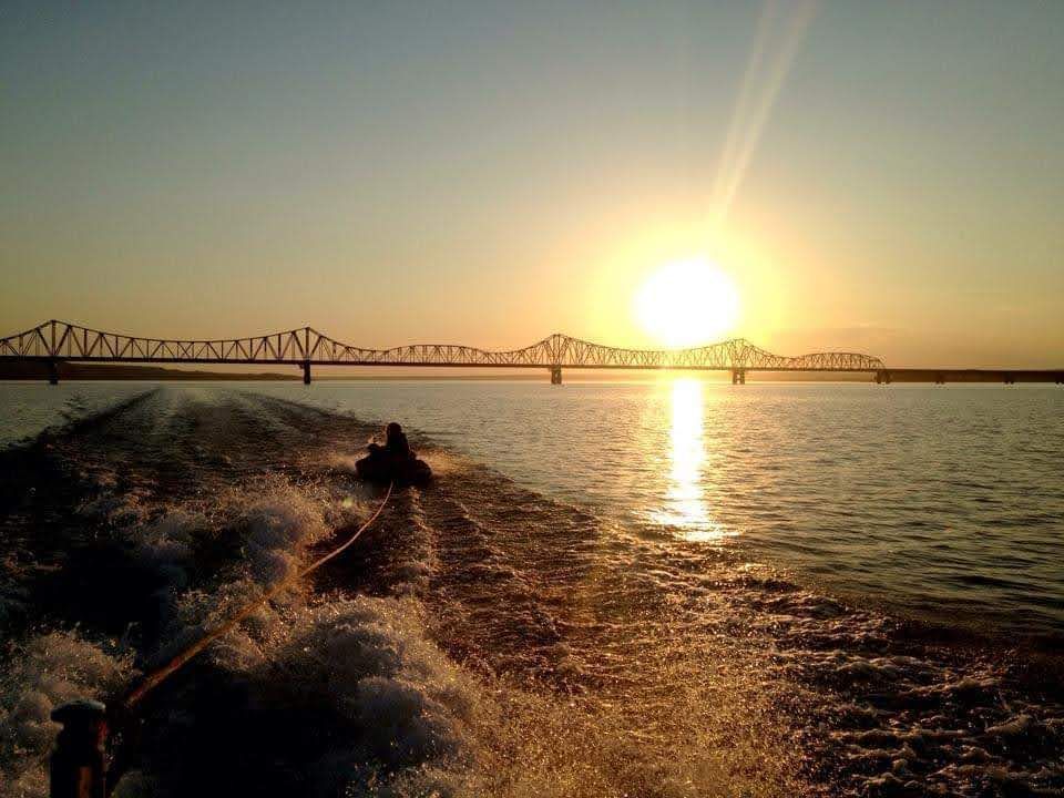 A person is riding a jet ski in the water at sunset.