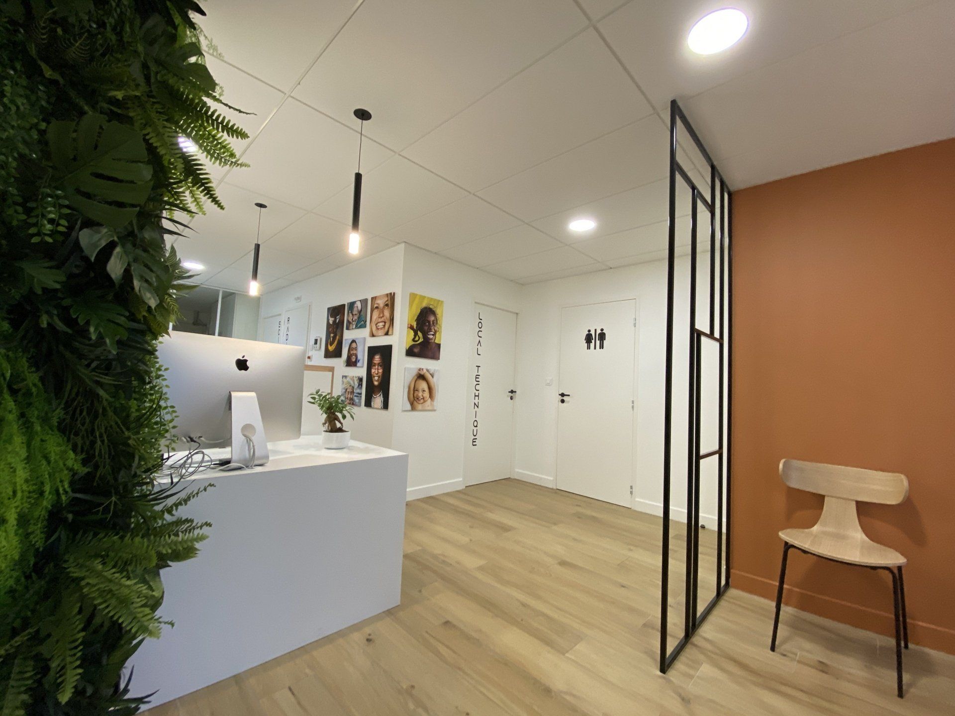 Hall d'entrée moderne et lumineux avec comptoir d'accueil, mur vert, portes blanches 