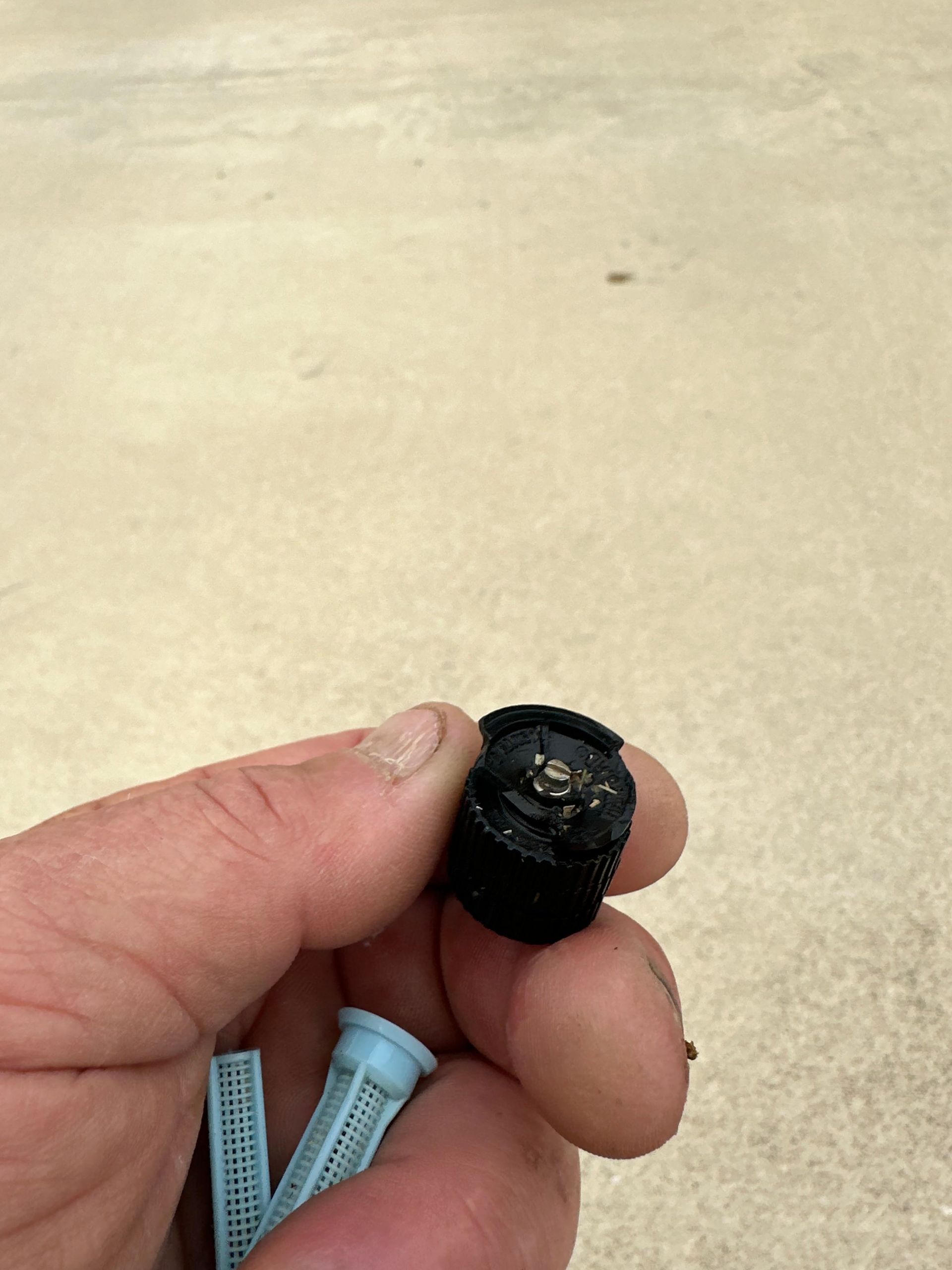 A person is holding a black object in their hand.
