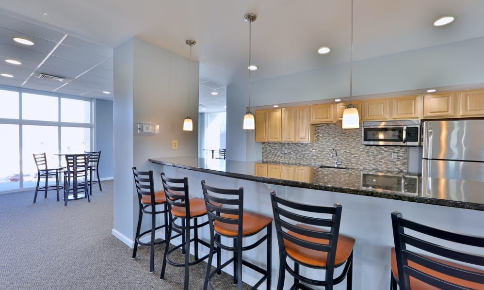 Bright modern kitchen with granite island, wood barstools, and stainless steel appliances