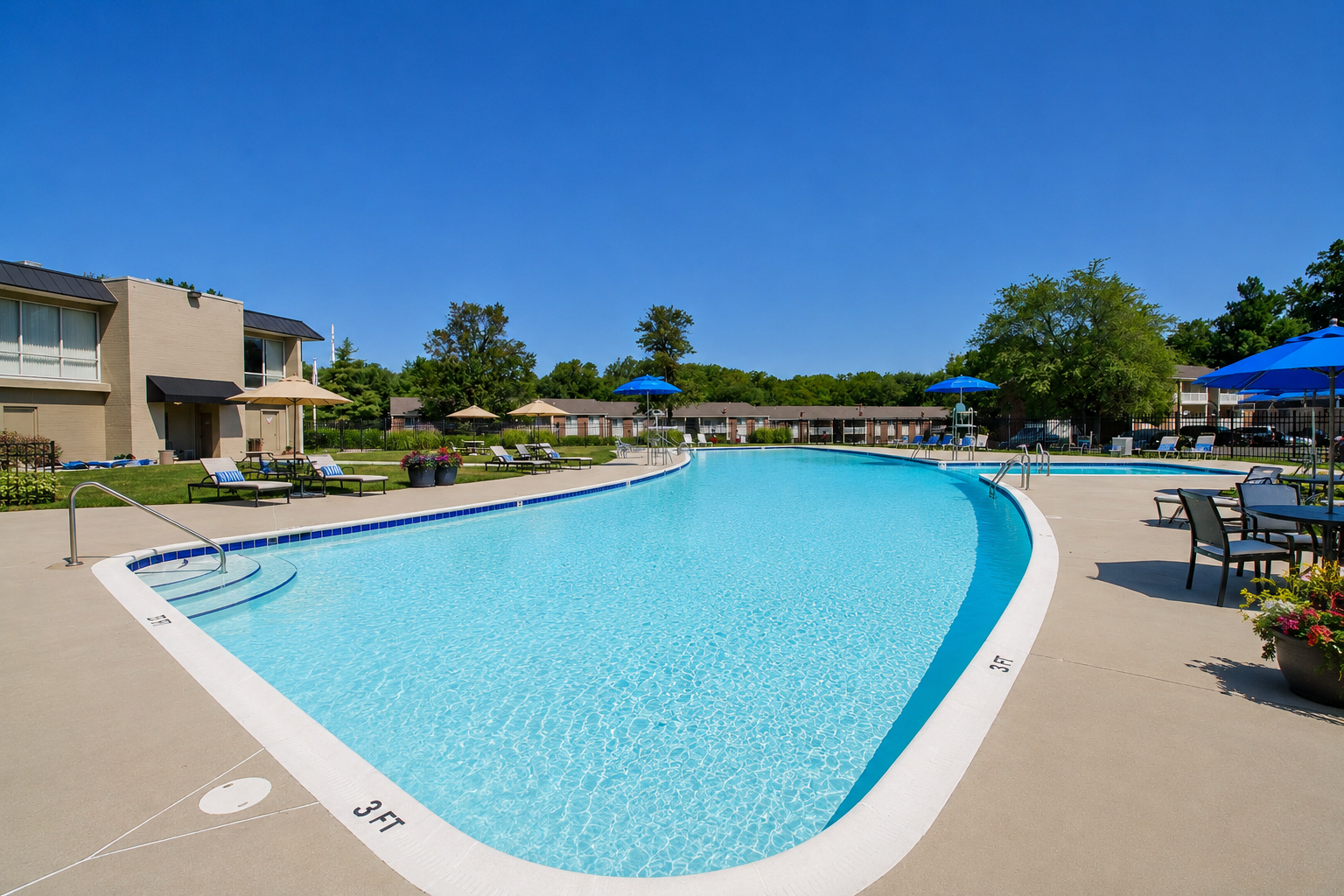 Outdoor swimming pool with clear blue water, beige deck, and lounge chairs under a sunny sky