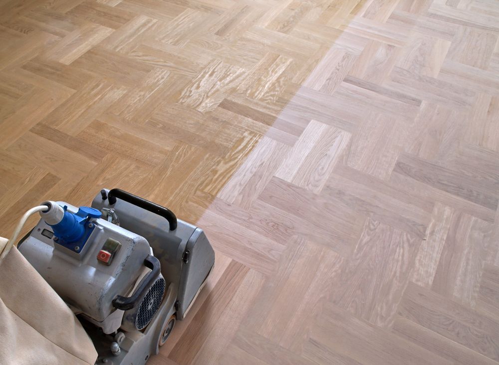 A Machine Is Being Used To Sand A Wooden Floor — Wyong Commercial Cleaning In Wyongah, NSW