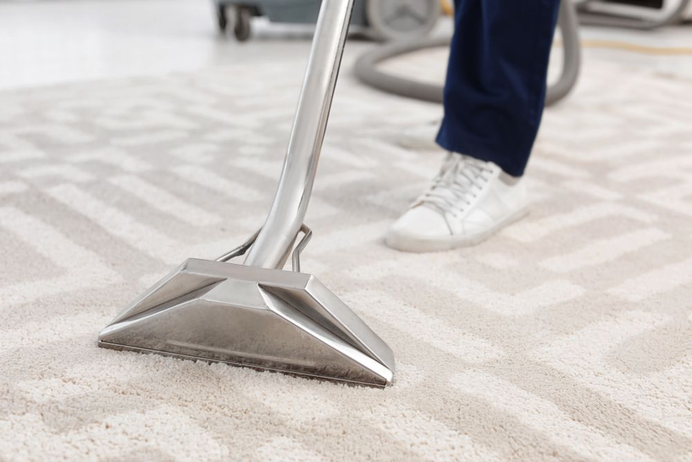 A Person Is Using A Vacuum Cleaner To Clean A Carpet — Wyong Commercial Cleaning In Berkeley Vale, NSW