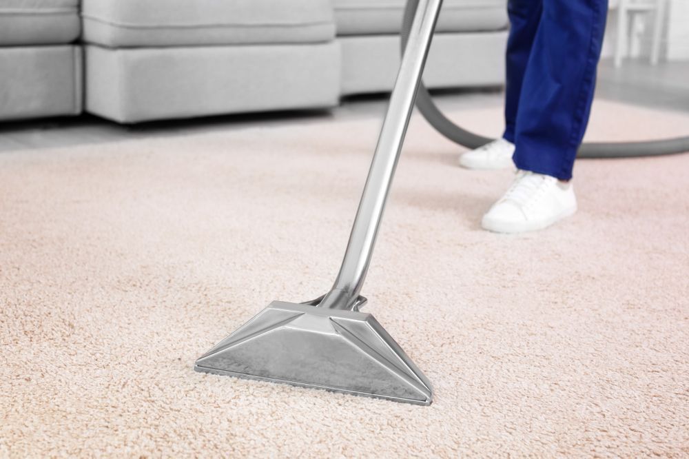 A Person Is Cleaning A Carpet With A Vacuum Cleaner — Wyong Commercial Cleaning In Morisset, NSW