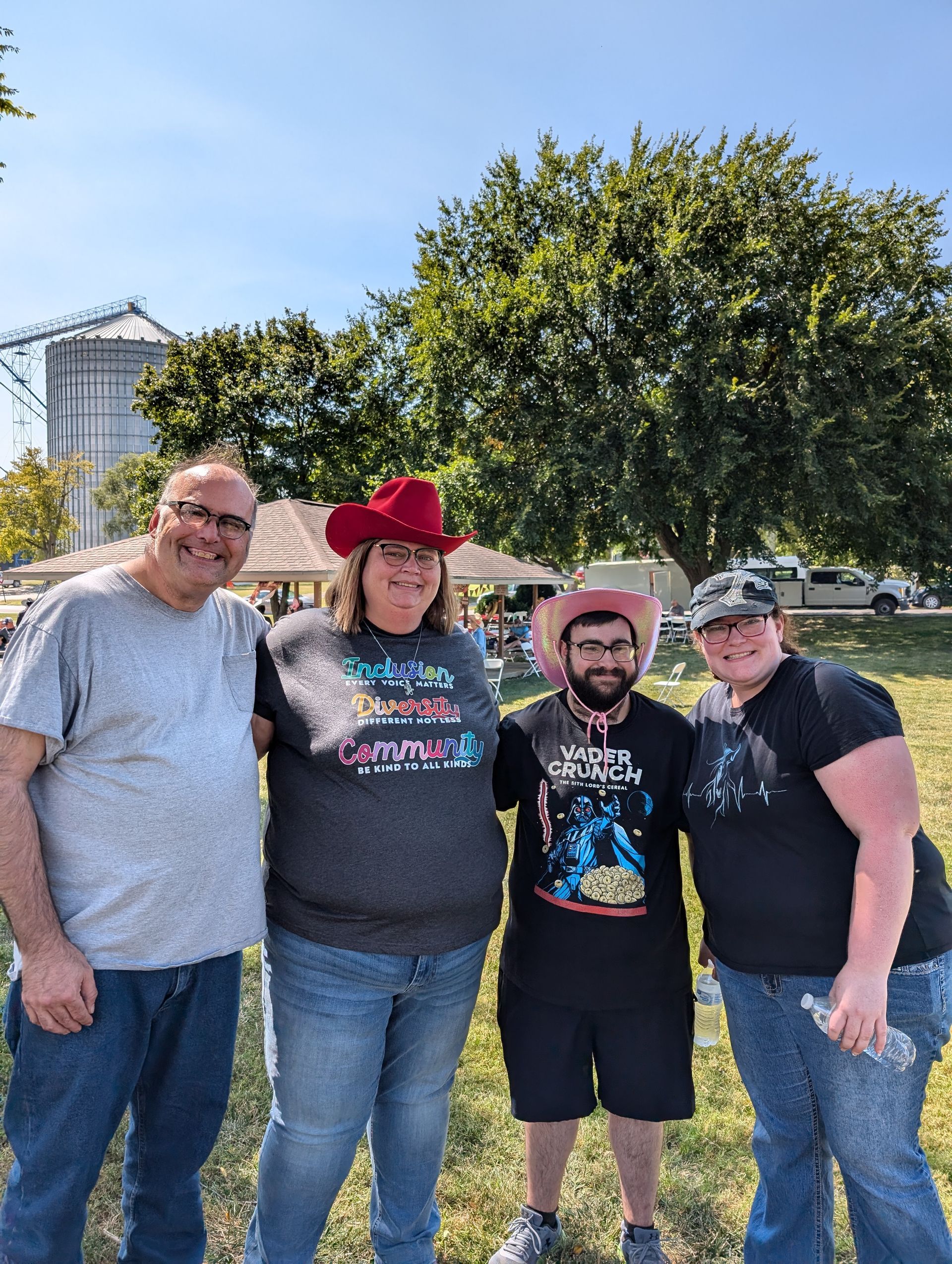 A group of people are posing for a picture in a park.