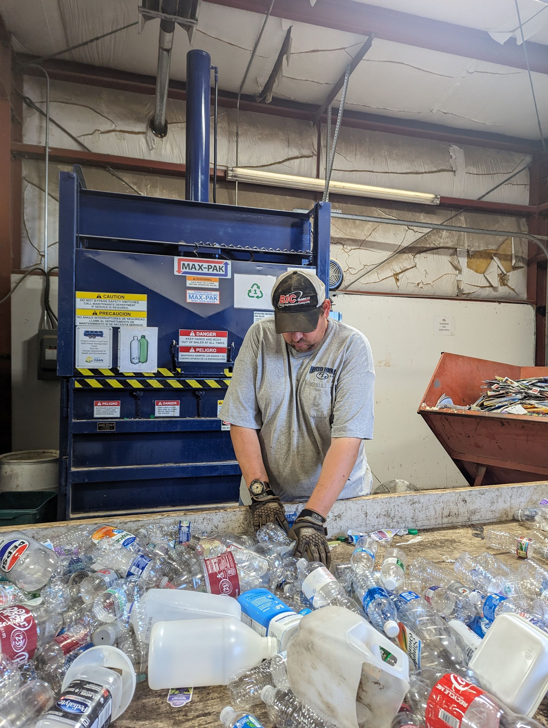 A man is working on a pile of plastic bottles.