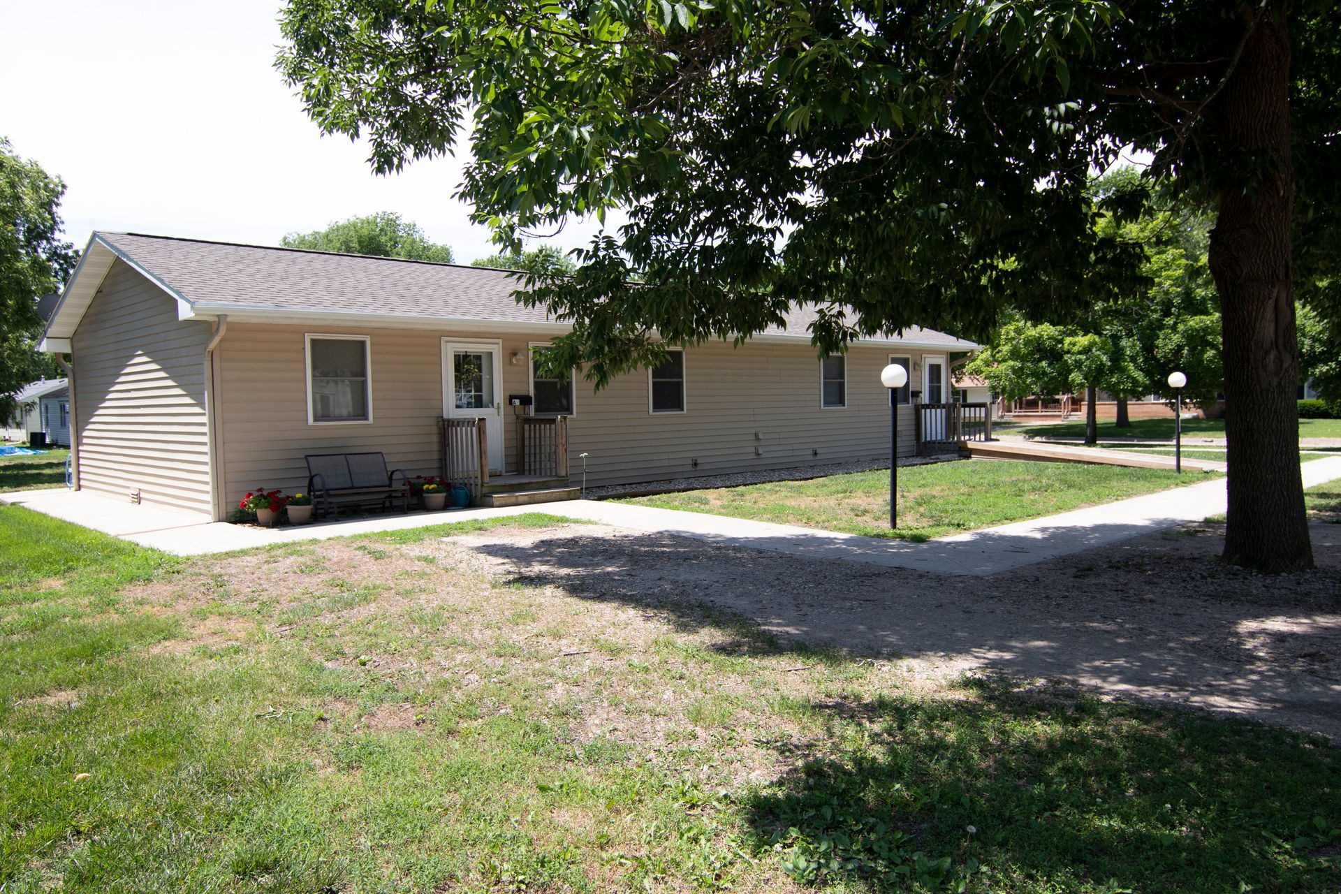 A house with a walkway and a tree in front of it