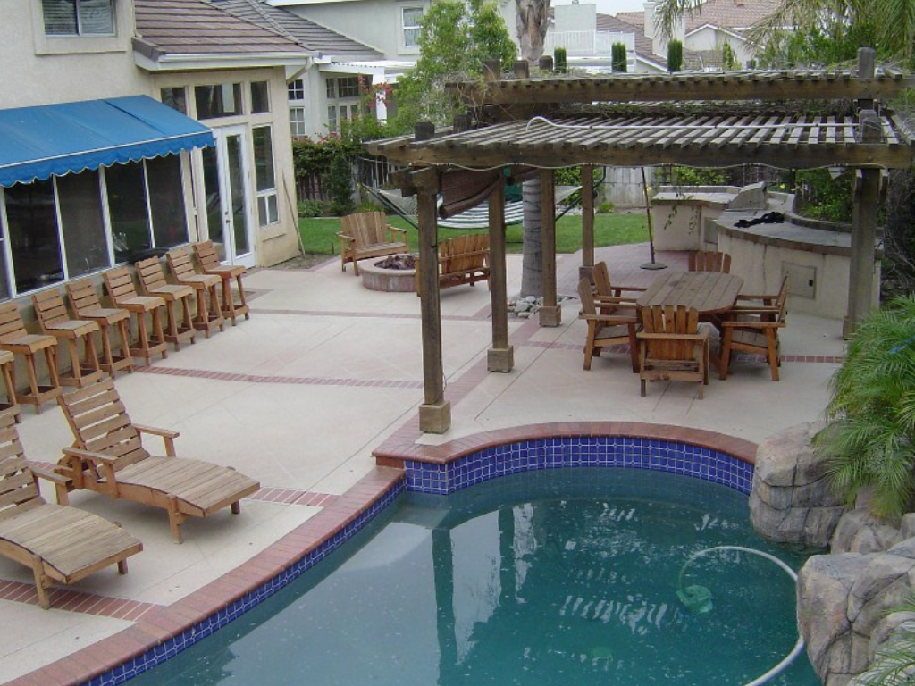 Backyard patio with pool, seating, and pergola.