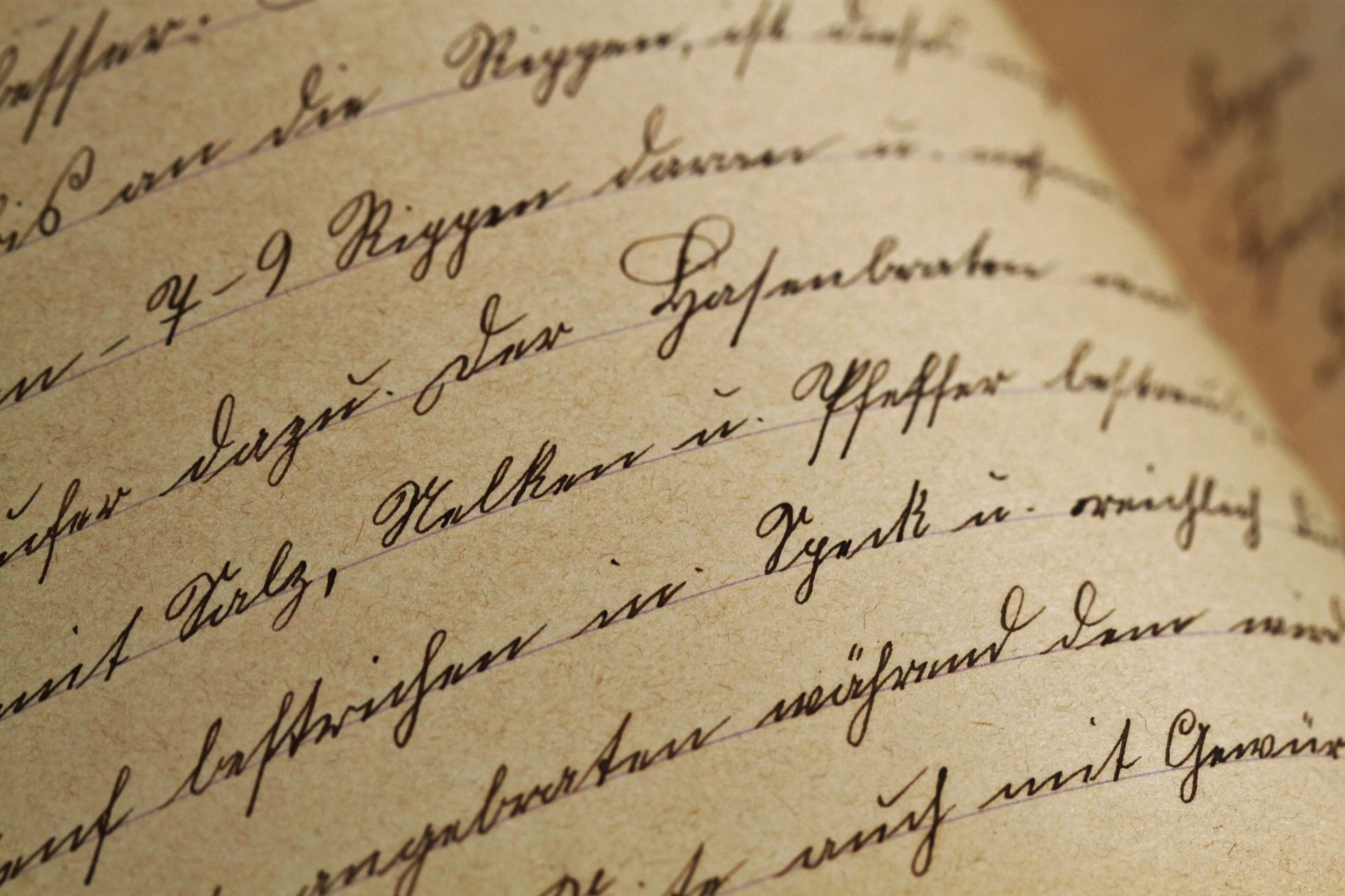 Close-up of handwritten cursive ink text on aged beige paper