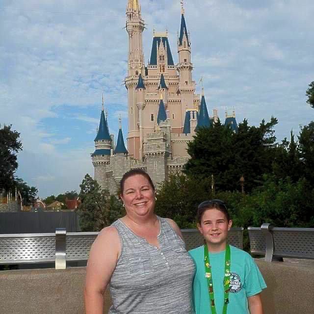 A woman and child pose in front of a castle