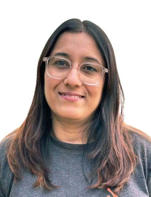 Portrait of a person wearing glasses and a gray shirt, smiling against a white background