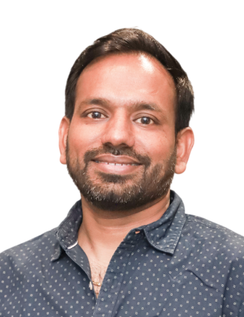 Smiling man in a dark patterned shirt against a white background