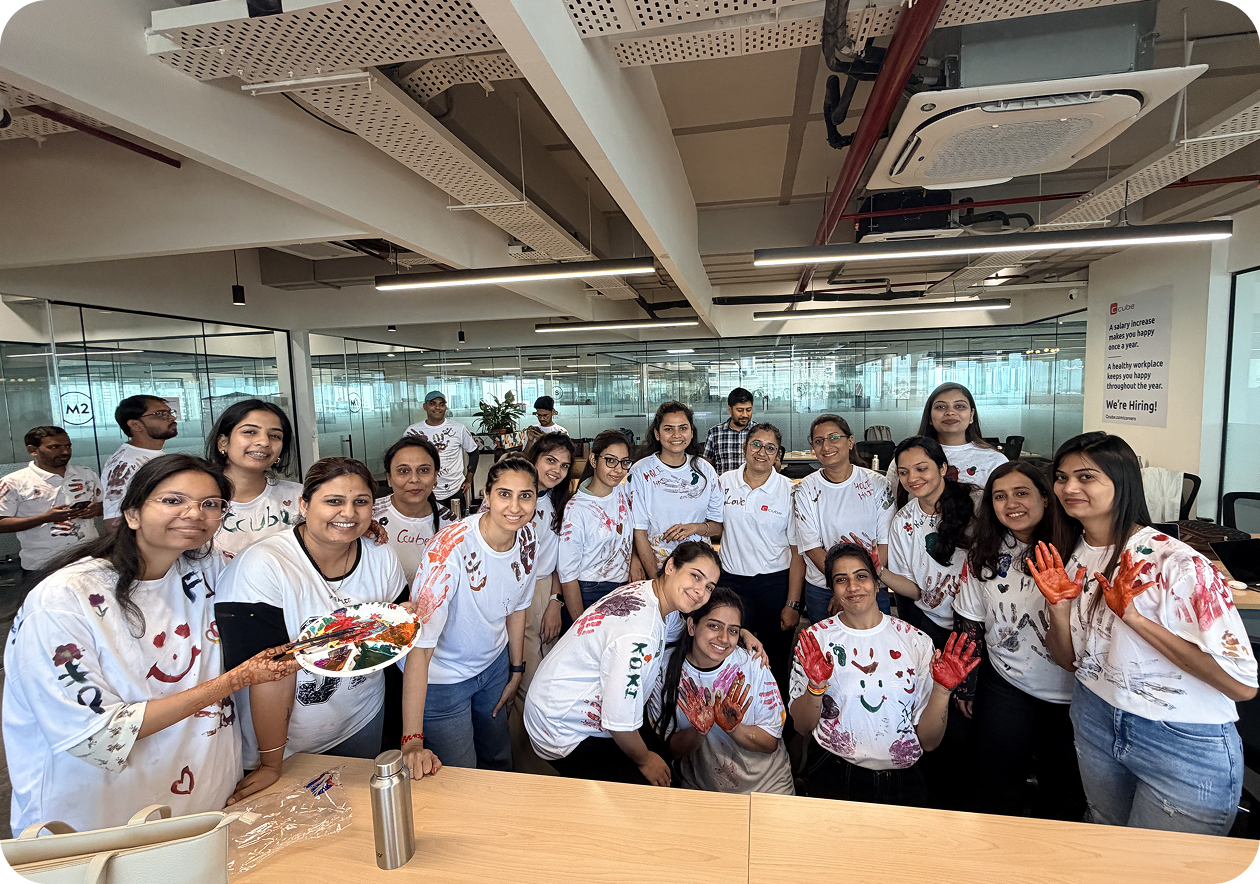 Group of people in white shirts posing together in a bright office or café setting