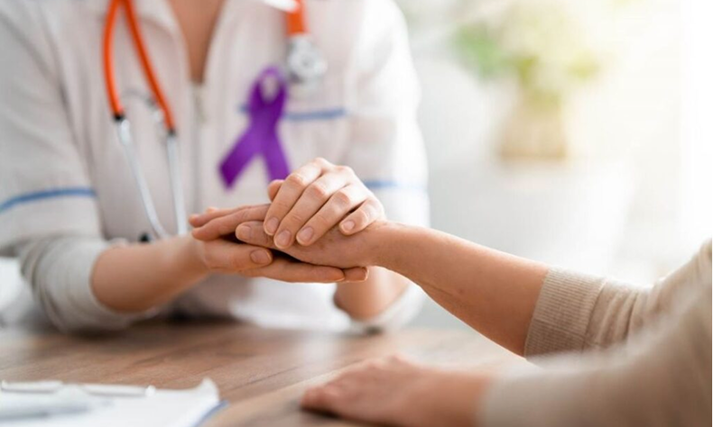 Healthcare worker holding a patient’s hand in a bright clinical setting