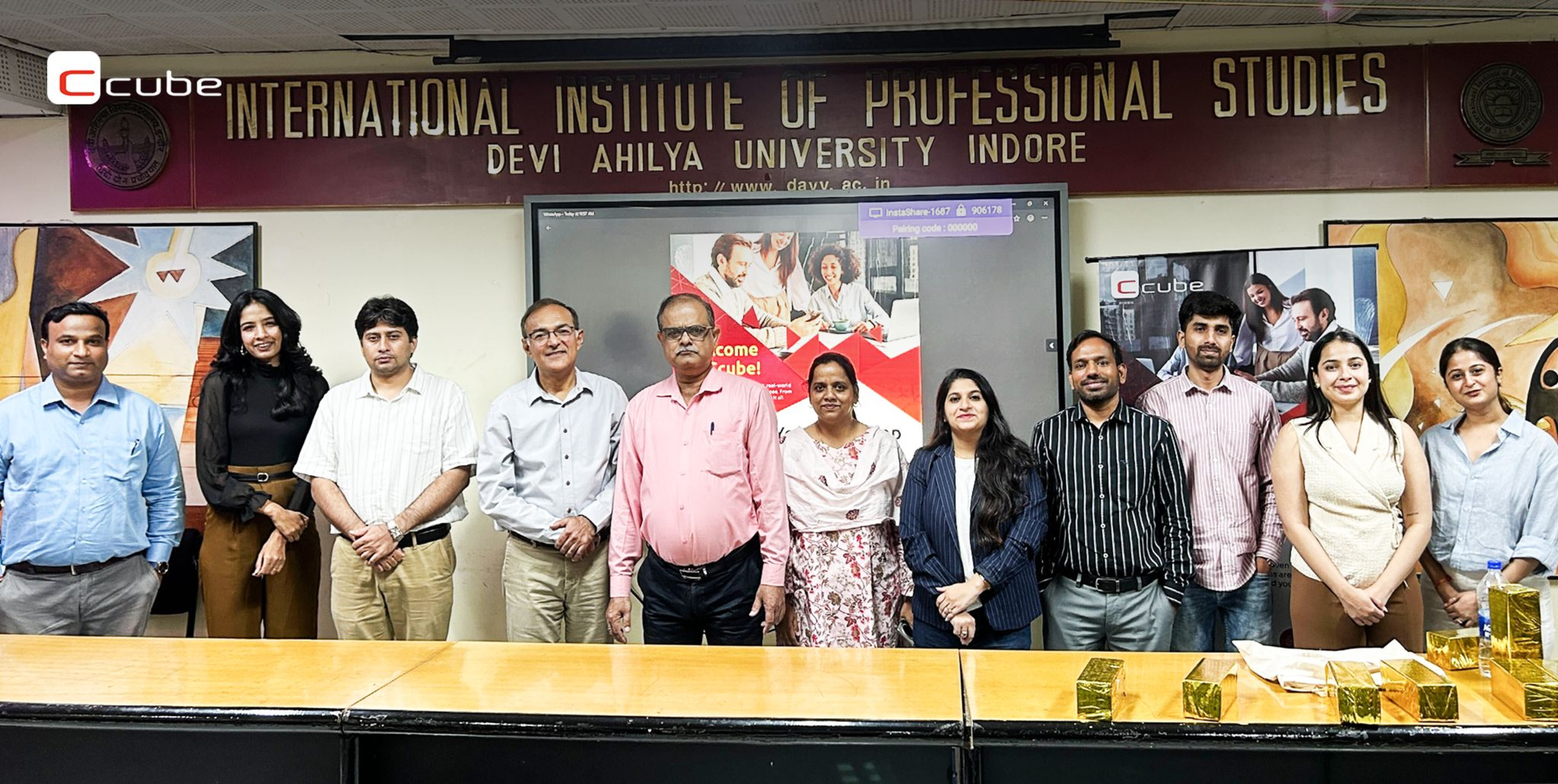 Group of people standing in front of the International Institute of Professional Studies sign at a campus event