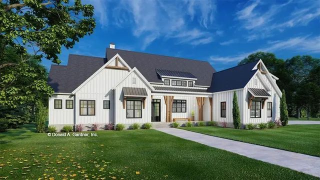 White farmhouse with black roof, dormers, and windows; green lawn.