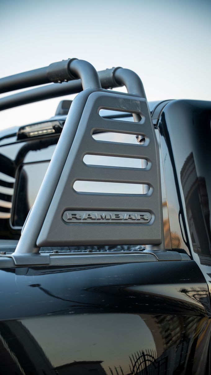 Silver off-road vehicle roof rack with ladder-like side support and black rails at sunset