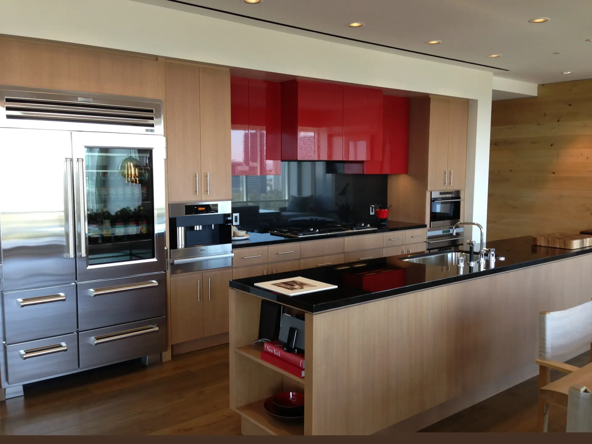 Modern kitchen with stainless appliances, red cabinets, and wood finishes