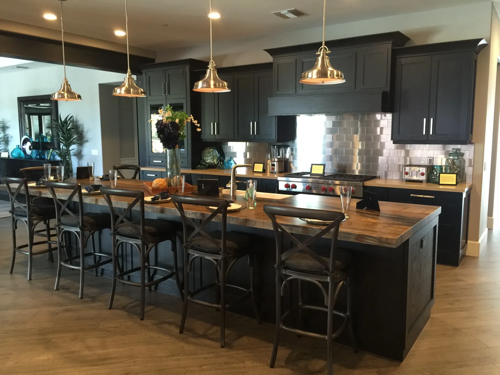 Modern kitchen with dark cabinets, large island, barstools, and pendant lights