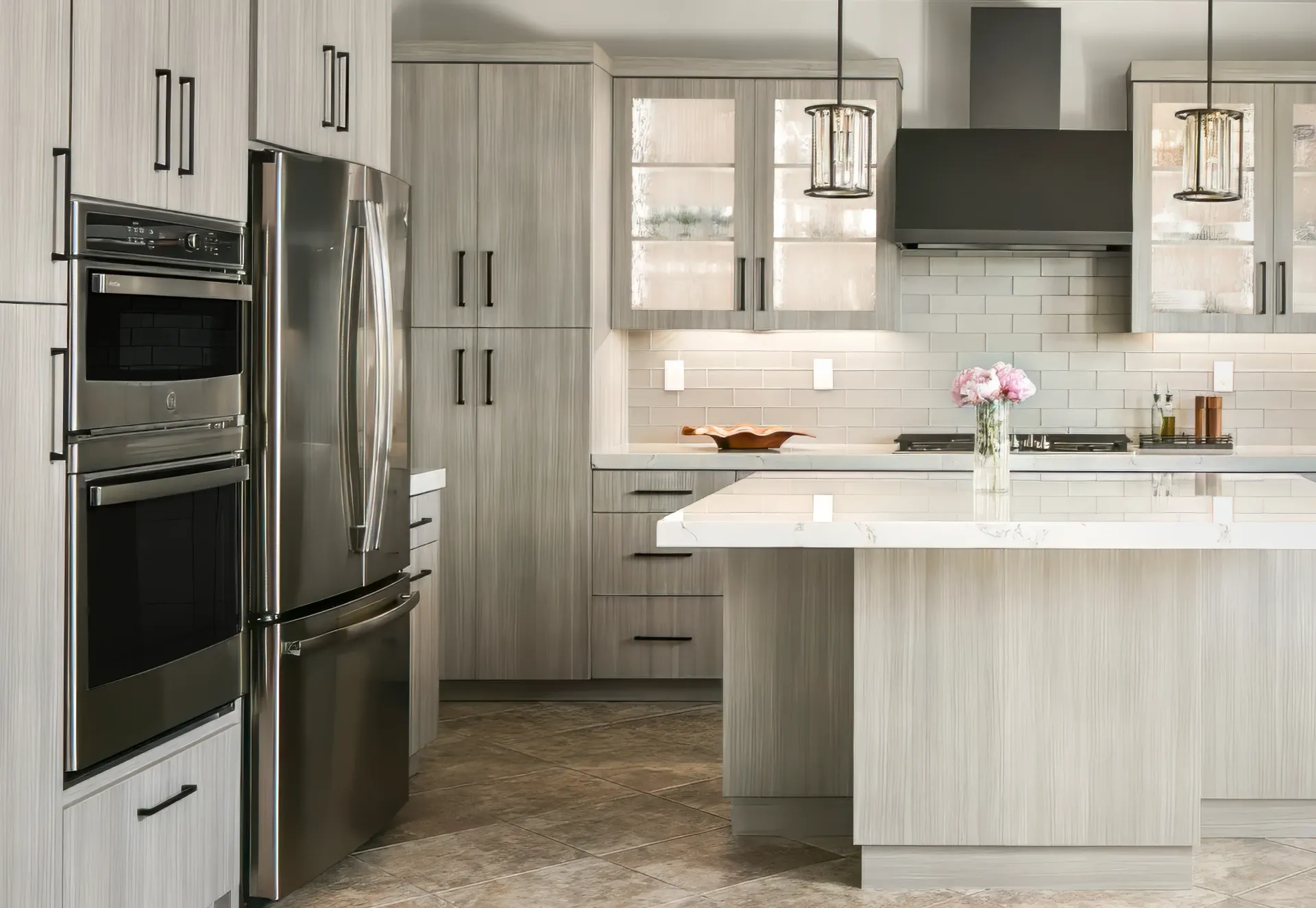 Modern gray kitchen with island, stainless steel appliances, and white countertops