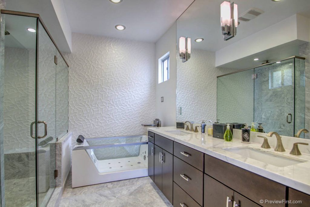 Modern bathroom with glass shower, soaking tub, and double vanity with large mirror