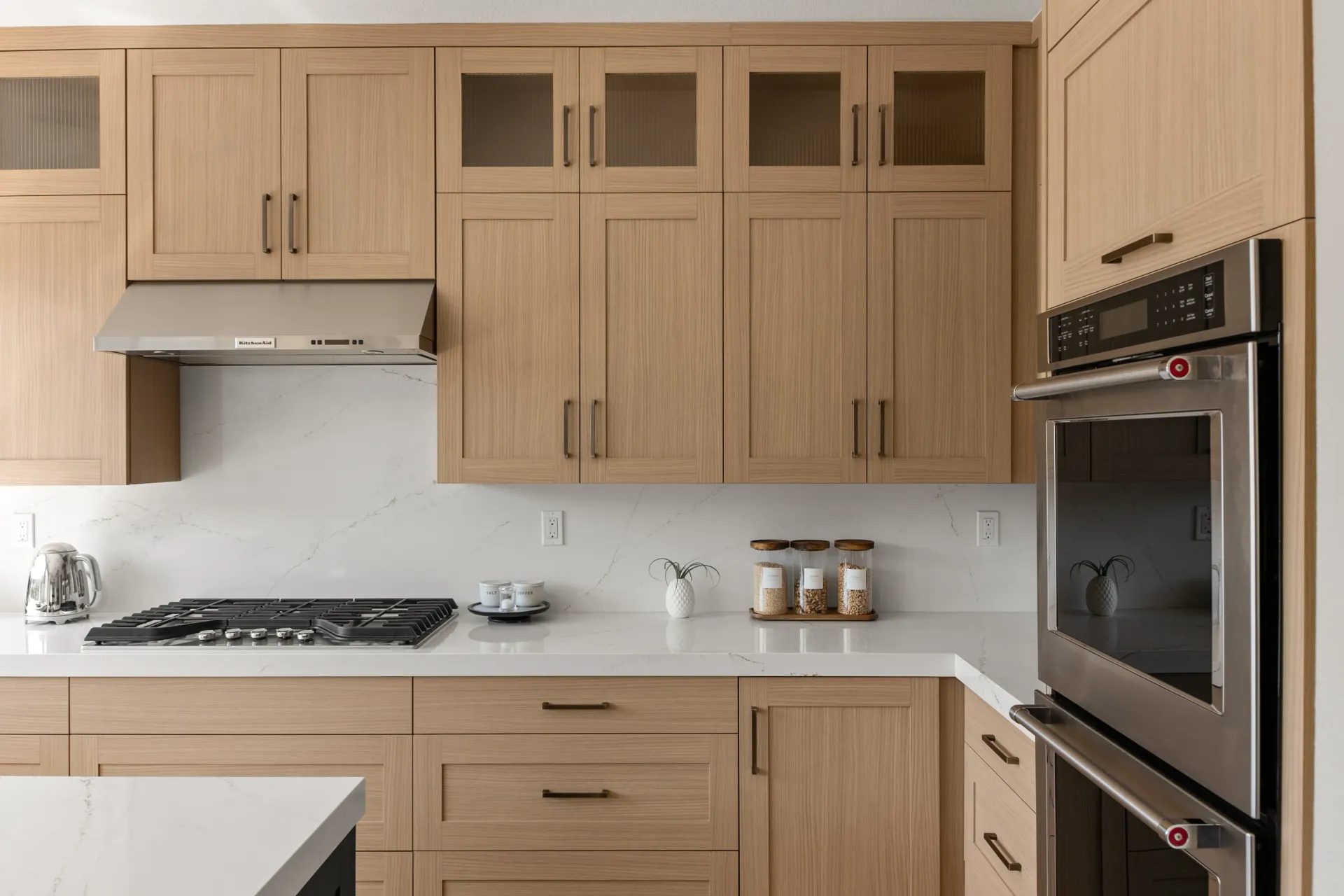Modern wood kitchen with white countertops, built-in oven, gas stove, and upper cabinets