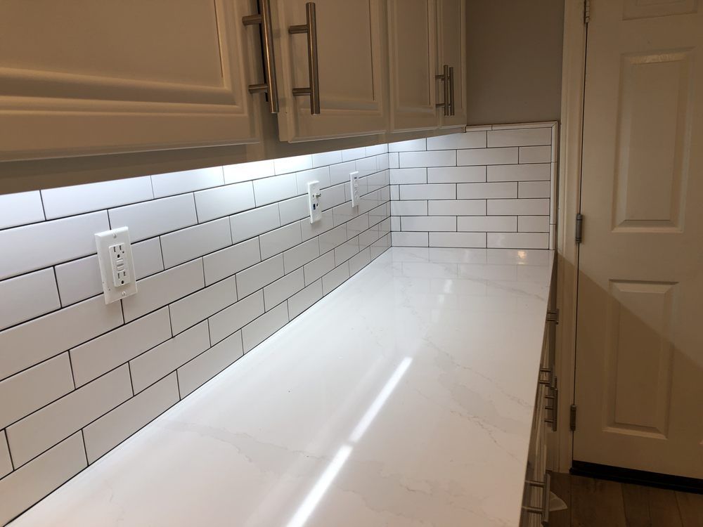 Empty kitchen counter with white subway tile backsplash and under-cabinet lighting