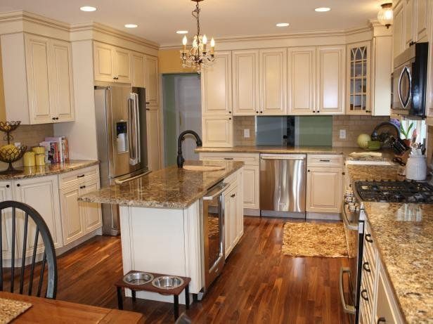 Bright kitchen with white cabinets, granite island, stainless appliances, and hardwood floors