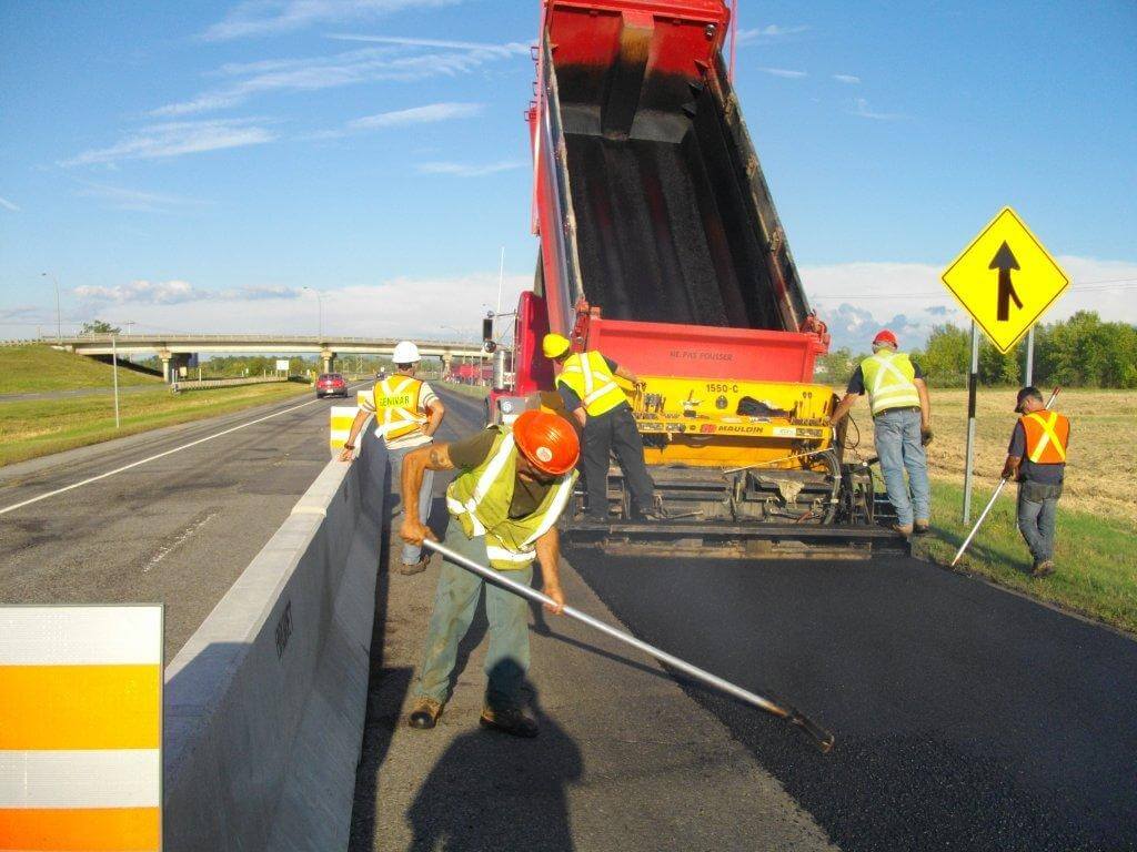 Un groupe de travailleurs de la construction travaillent sur une autoroute