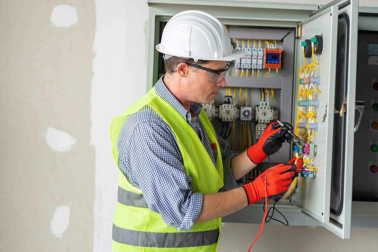 Licensed electrician replacing outdated home electrical panel with modern circuit breaker panel.