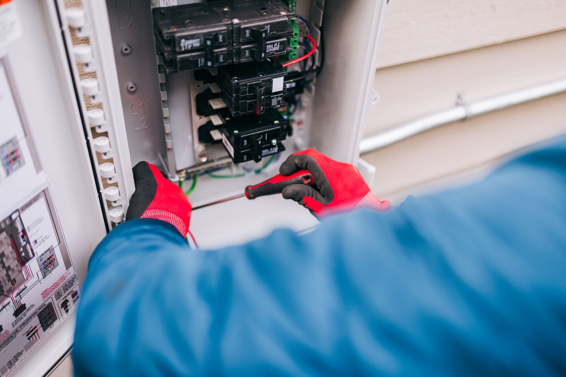 Patriot electrician inspecting outdated electrical panel in older Le Pere Wisconsin home.