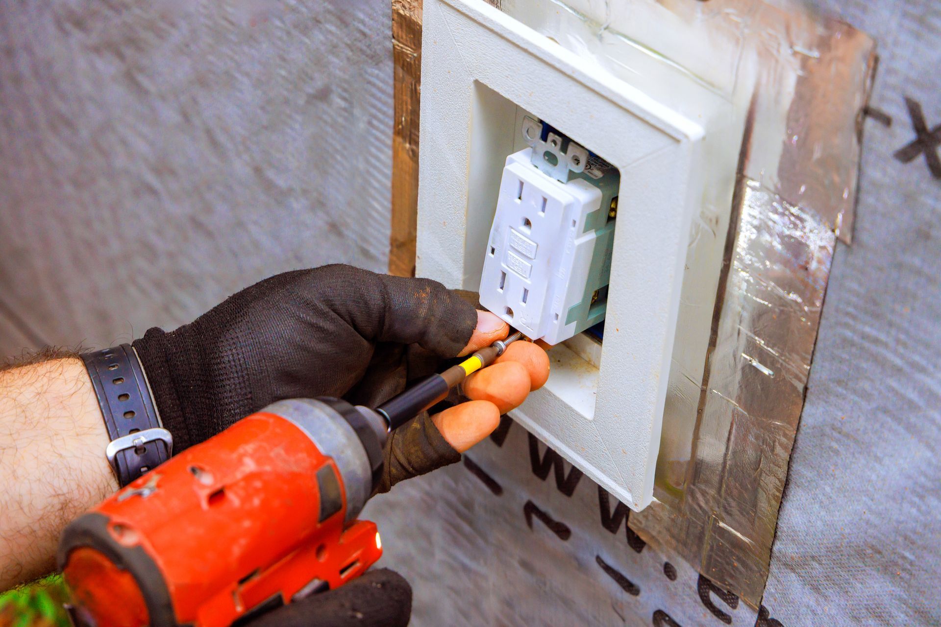 Electrician installing a whole-home surge protector inside a residential electrical panel.