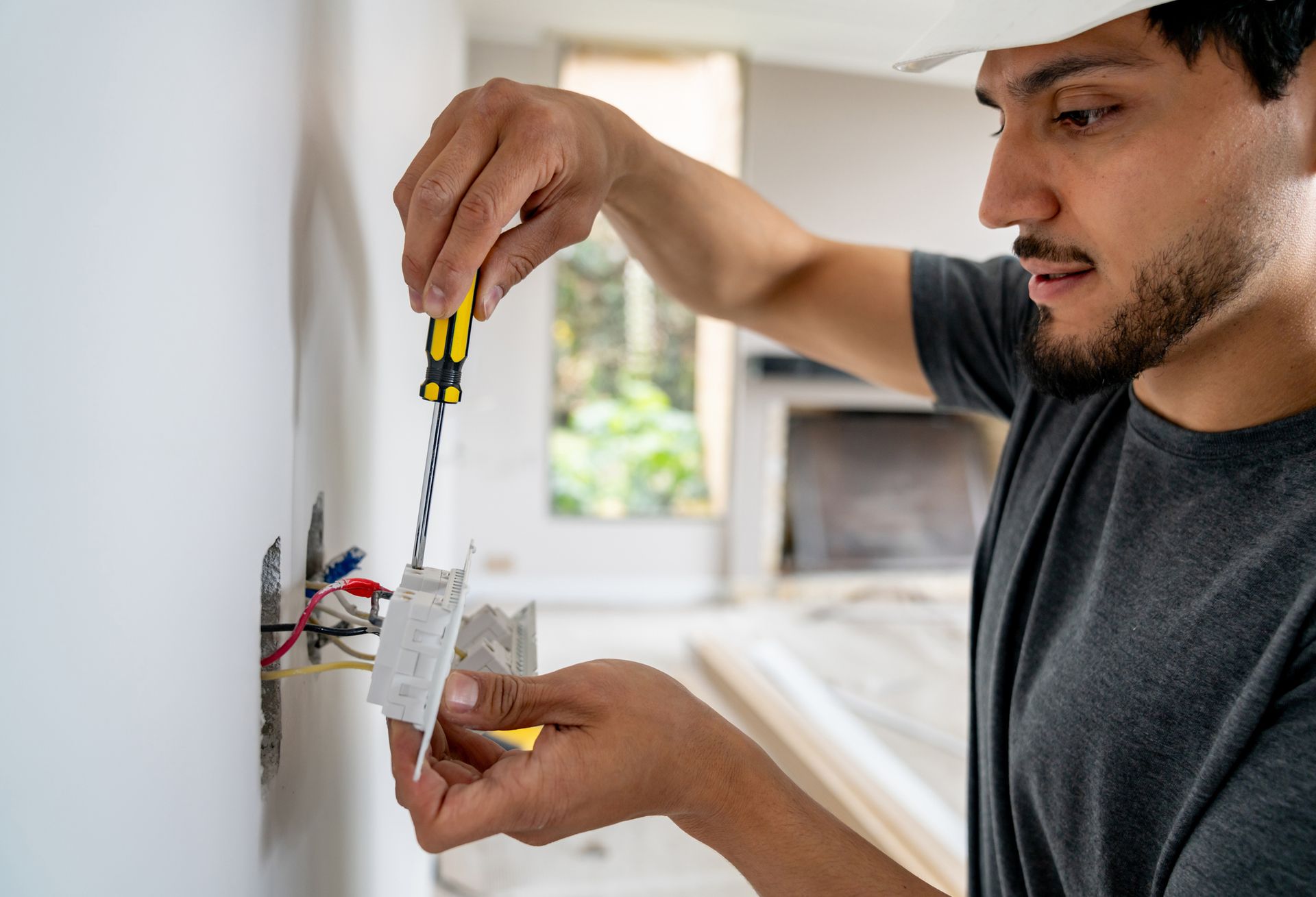Electrician installing a new power socket with precision and care. Electrician installing a new power socket with precision and care.
