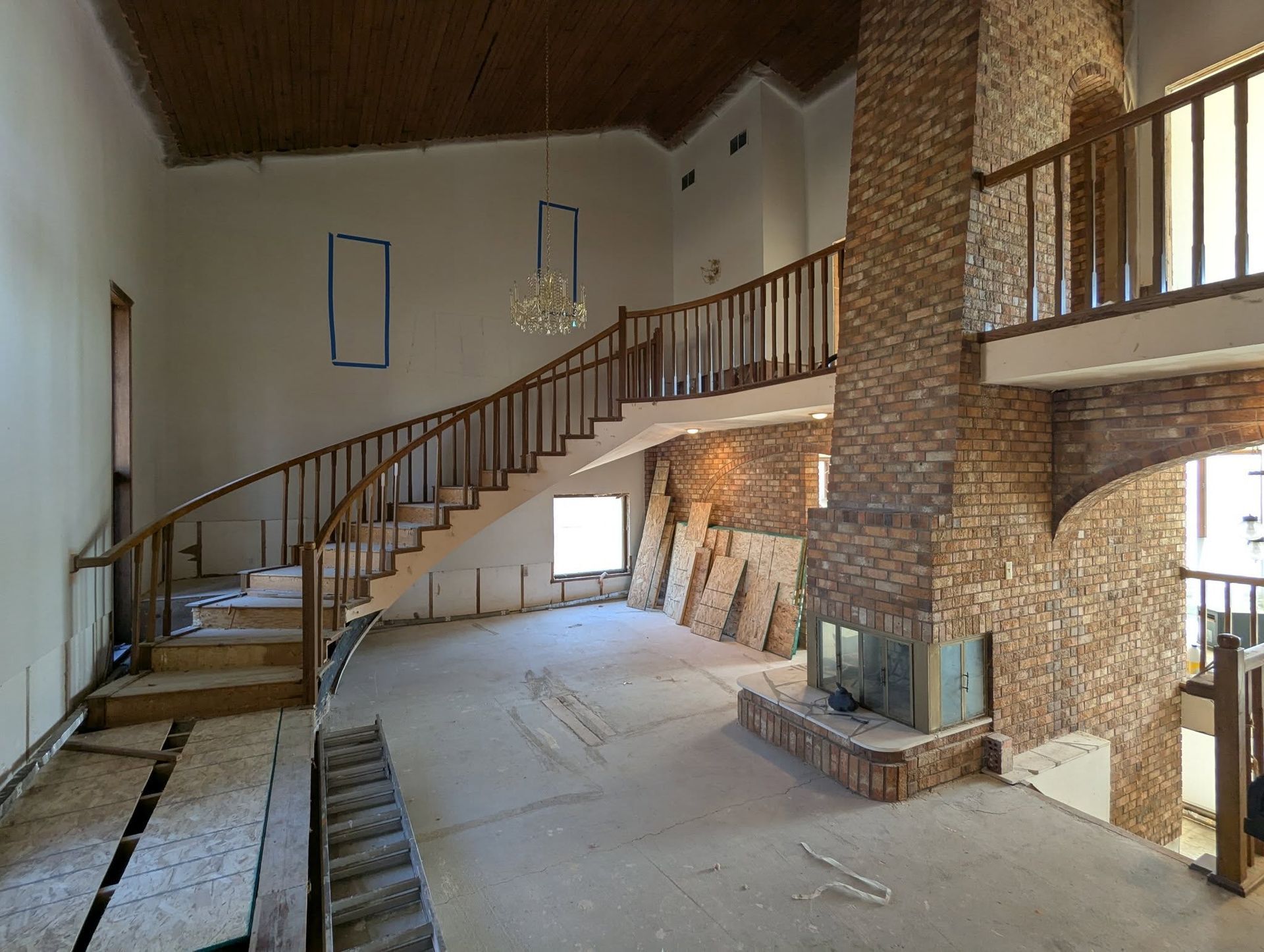 A large empty room with stairs and a fireplace