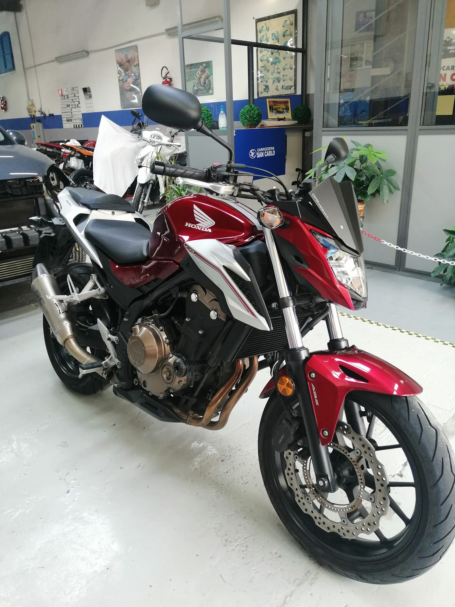 Motocicletta rossa e nera parcheggiata all'interno di uno showroom.